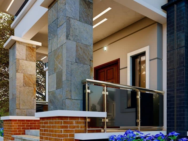 Stone-clad porch columns and glass railing illustrating porch railing connections in masonry